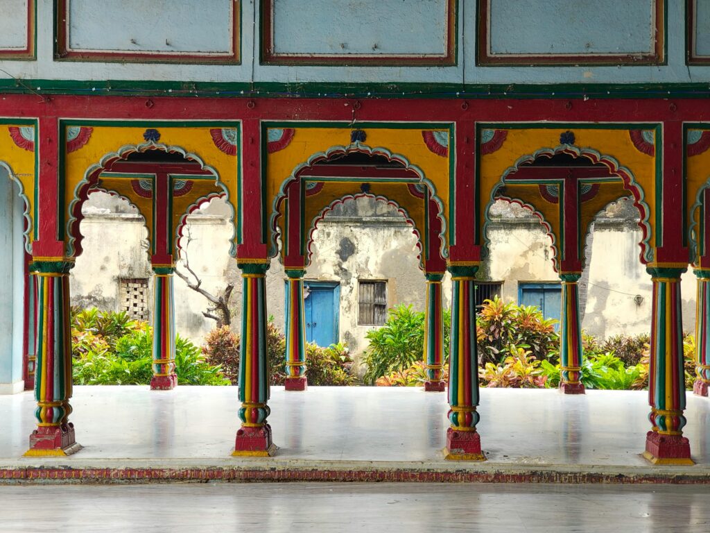 Vibrant arches with intricate designs in traditional architecture, tropical plants in the background.